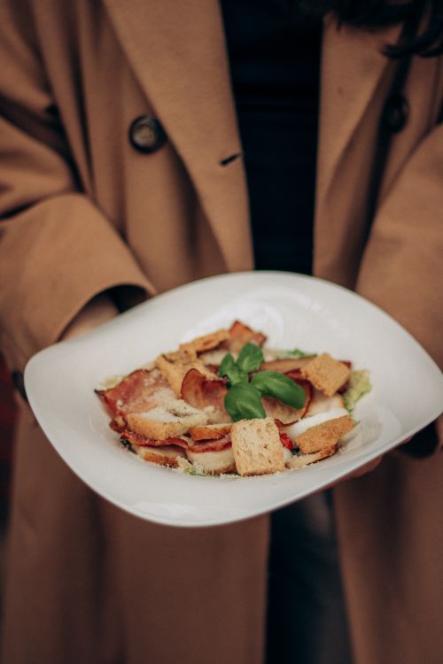Free A close-up of a classic Caesar salad with croutons and fresh basil, elegantly presented. Stock Photo