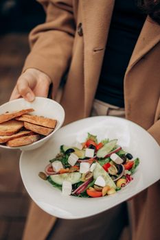 Close-up of a colorful Mediterranean salad with fresh vegetables and bread slices.