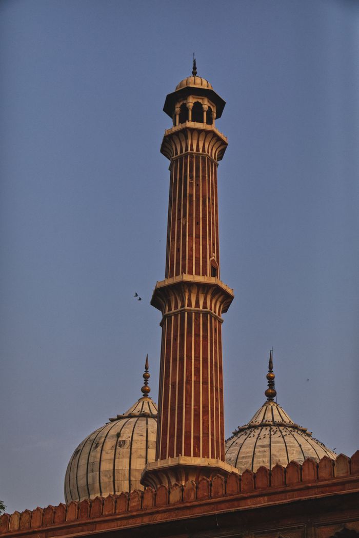 A tall stone minaret rising against a dusk sky