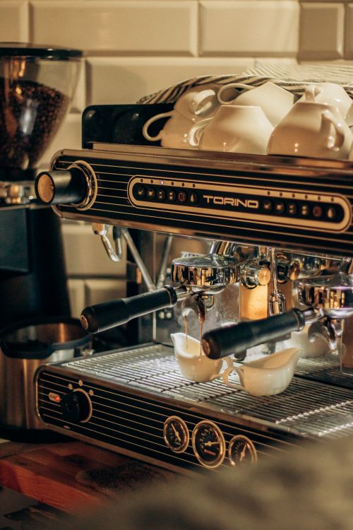 Free A vintage espresso machine with cups stacked on top, creating a cozy cafe vibe. Stock Photo