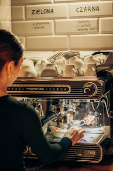 A barista uses a professional espresso machine in a cozy cafe setting, preparing a hot beverage.