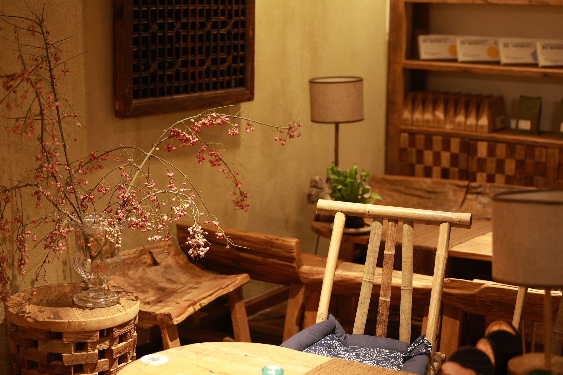 Interior cálido y acogedor de una cafetería en Valencia con luz natural, mesas de madera, clientes disfrutando café y pasteles