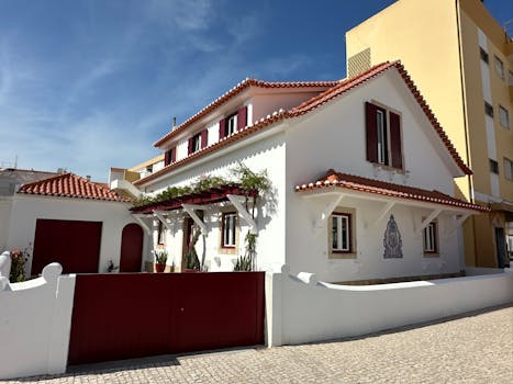 Beautiful traditional Portuguese house with red roof tiles and white walls in a sunny setting.