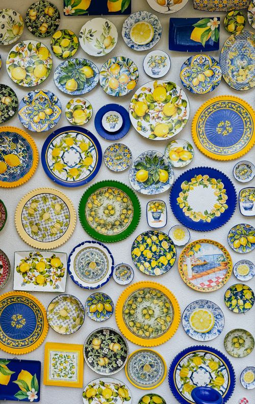 Free Collection of handmade ceramic dishes with lemon patterns in blue and yellow color palette. Stock Photo