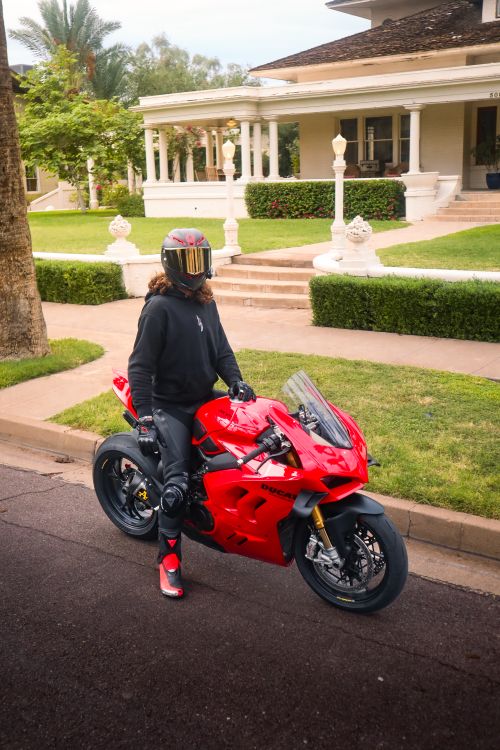 Free A rider with a helmet on a red motorcycle parked in a suburban neighborhood. Stock Photo