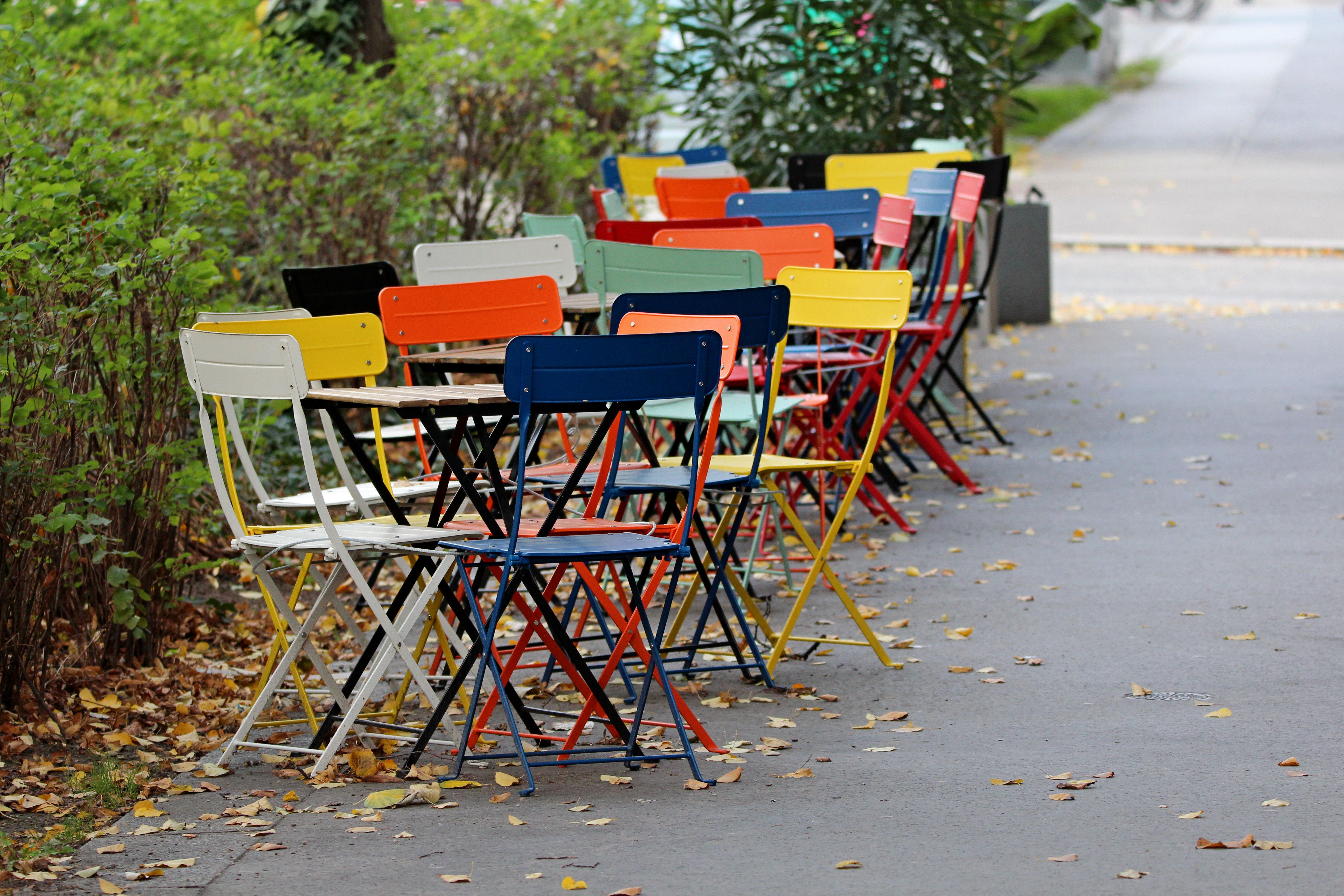Vibrant chairs arranged along a sidewalk in autumn, Wien.