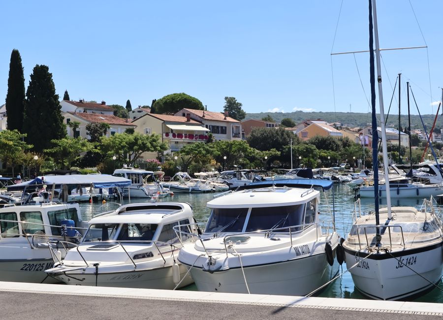 A picturesque marina with boats docked in a charming coastal European town.