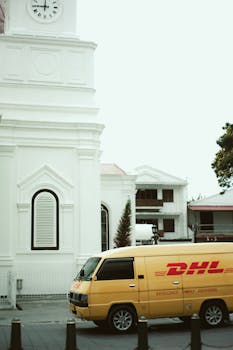 Yellow DHL van parked beside colonial-style building in Semarang, Indonesia.