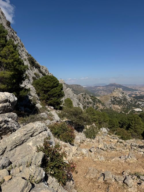 Free Breathtaking mountain landscape with rugged rocks and lush greenery under a clear blue sky. Stock Photo
