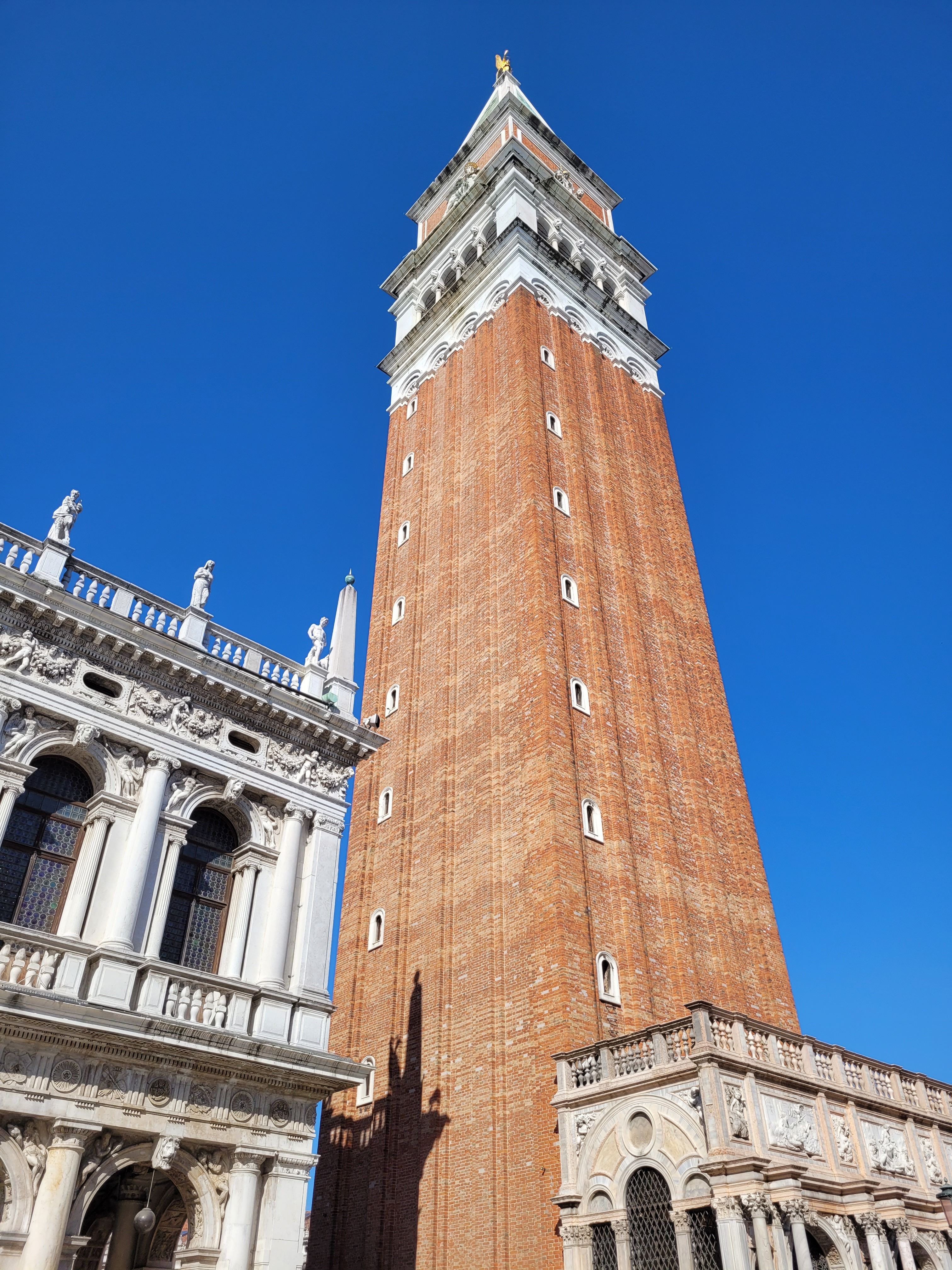 The iconic St. Mark's Campanile in Venice, Italy, soaring into a clear blue sky.