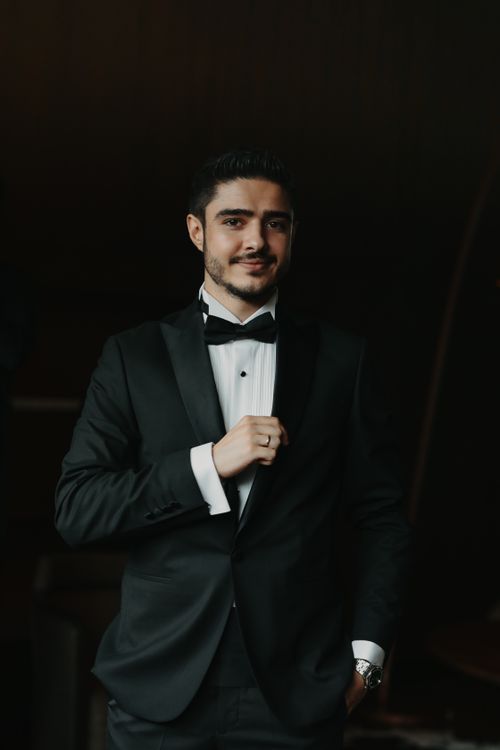 Free Portrait of a confident man in a classic black tuxedo, exuding elegance. Stock Photo
