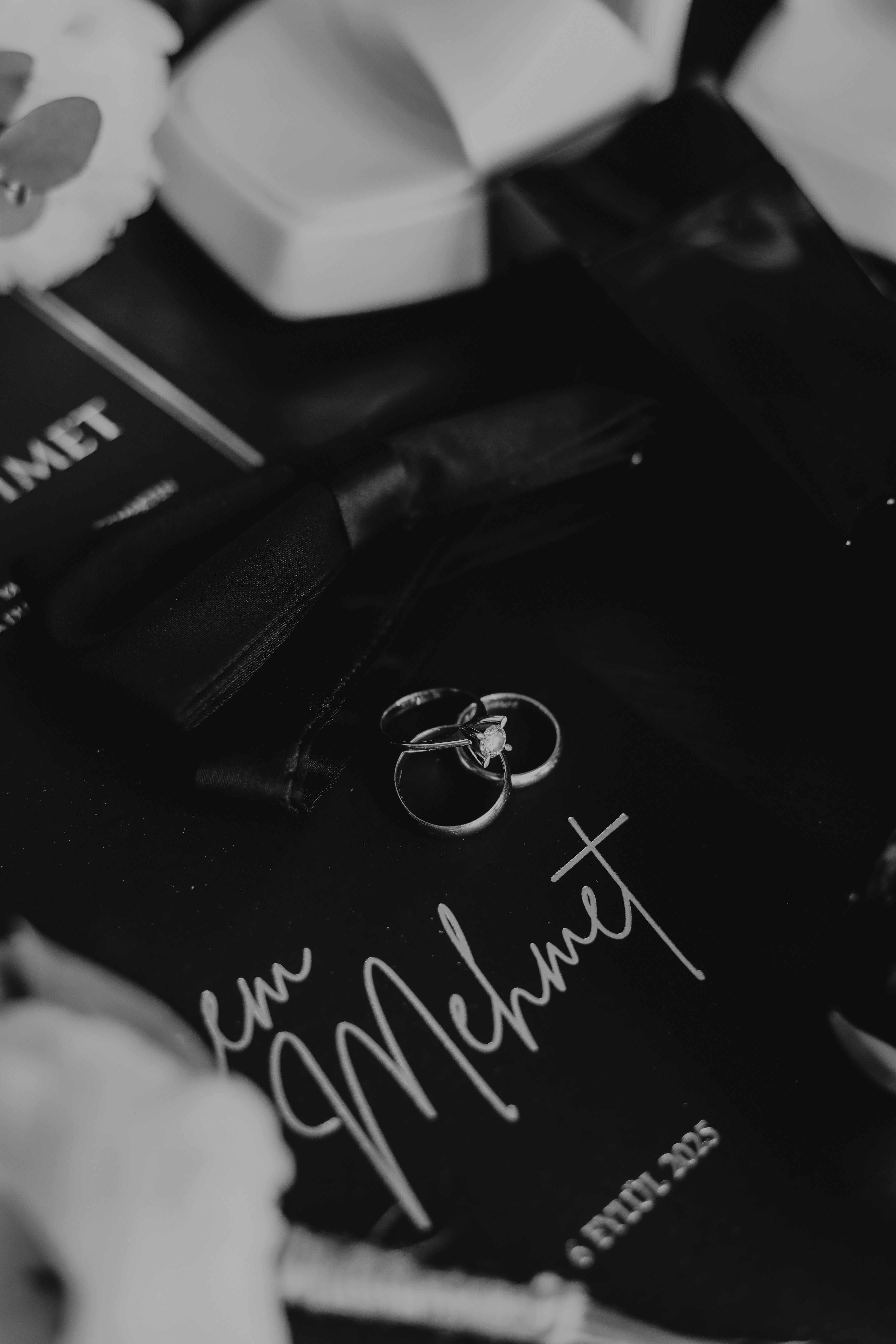 De franc Primer pla d'anells de casament i papereria en tons monocroms, creant una sensació atemporal. Foto d'estoc