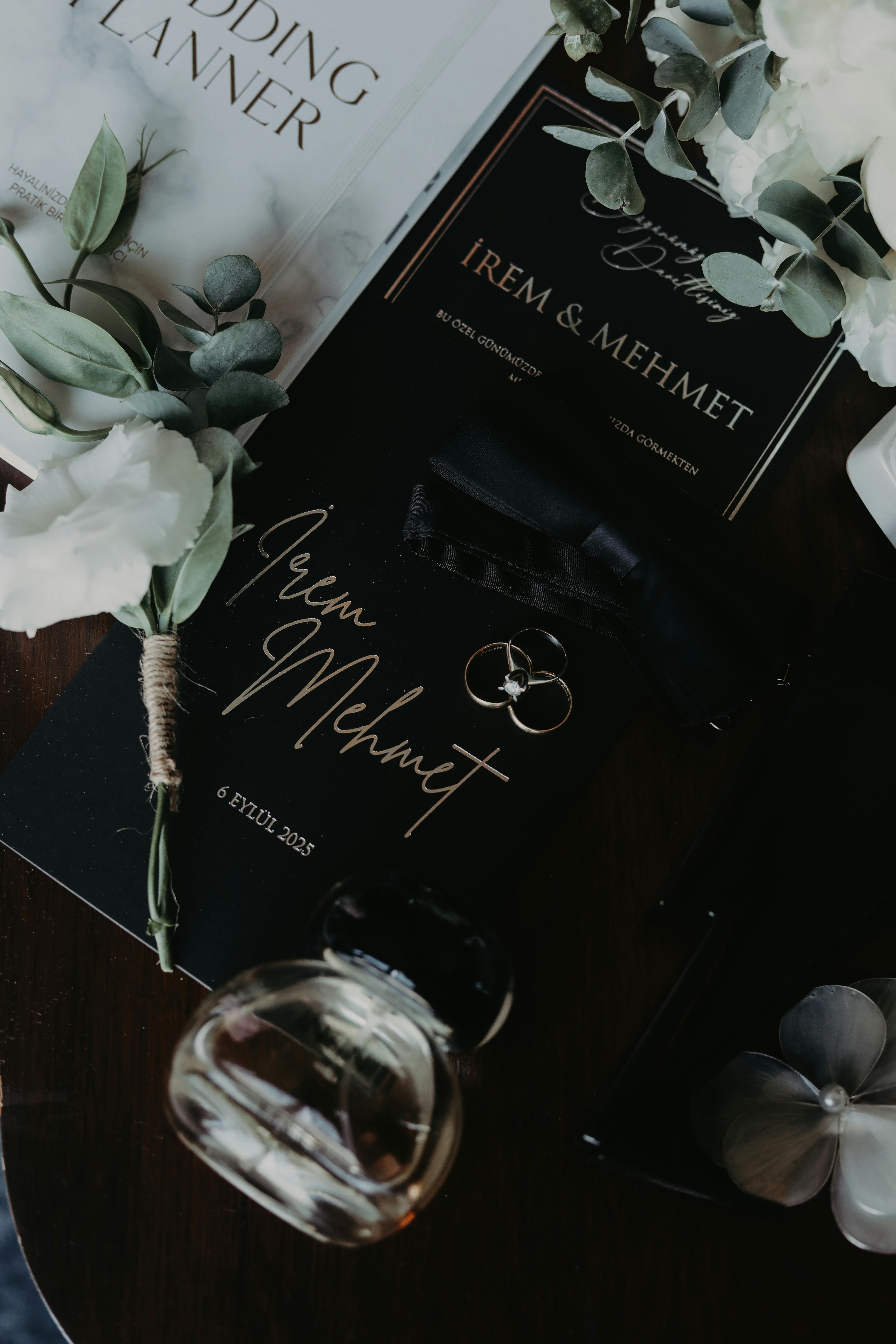 Elegant wedding invitation setup with floral accents and perfume bottle.