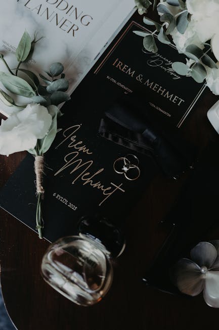 Elegant wedding invitation setup with floral accents and perfume bottle.