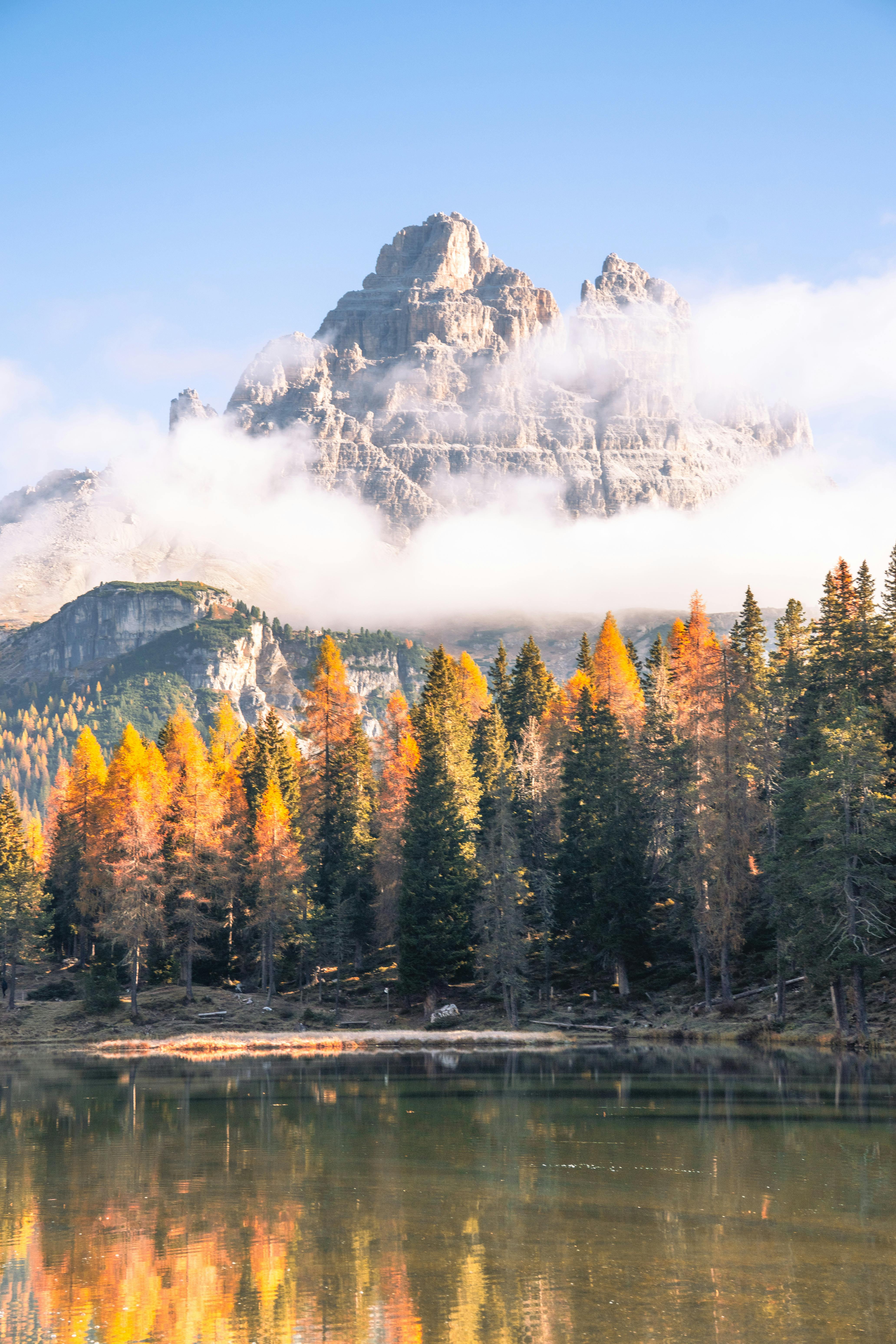 Beautiful autumn landscape of the Dolomites reflected in a serene lake at daytime.