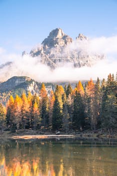 Beautiful autumn landscape of the Dolomites reflected in a serene lake at daytime.