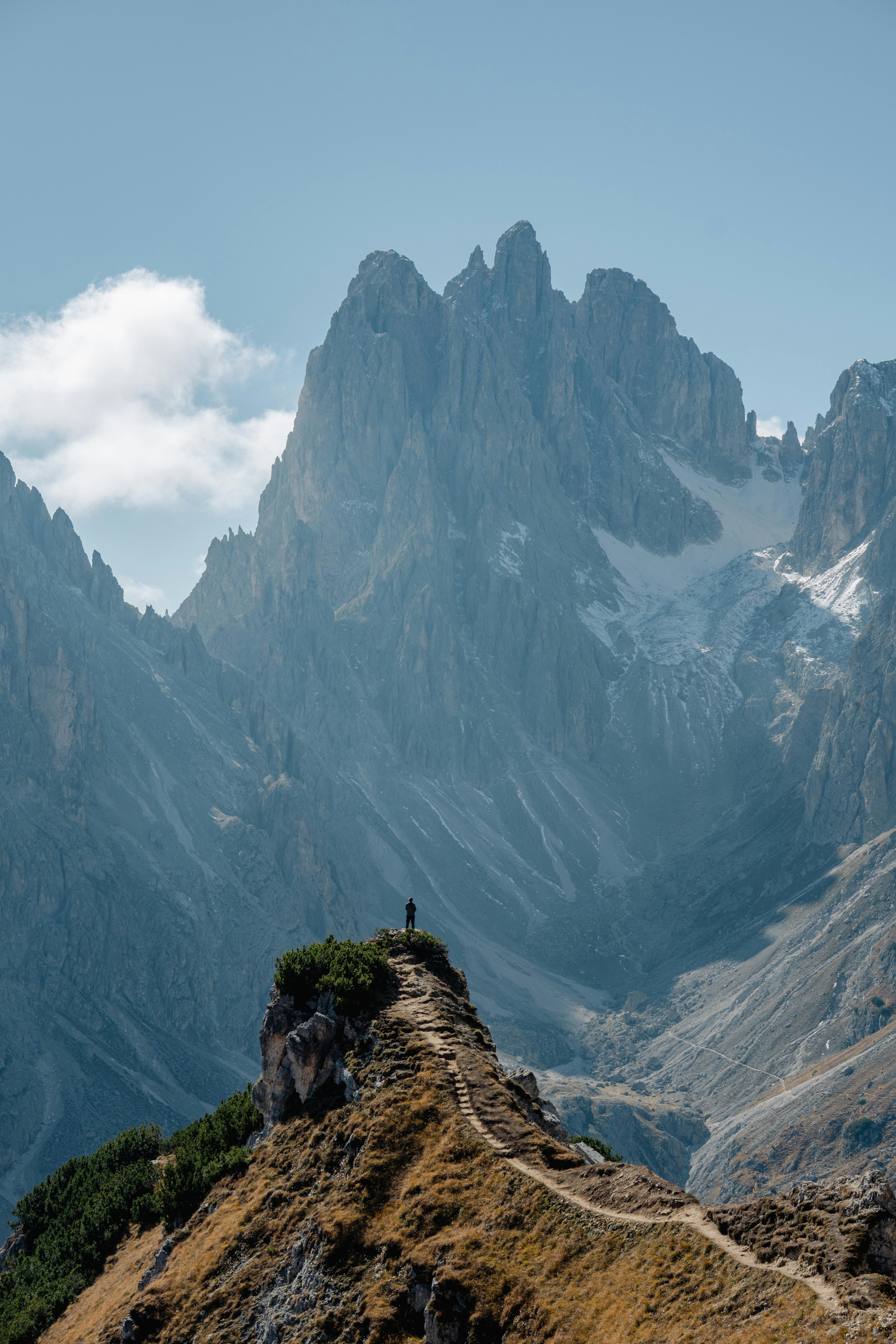 Explore the stunning mountain path in the Dolomites, Italy with breathtaking peaks and clear skies.