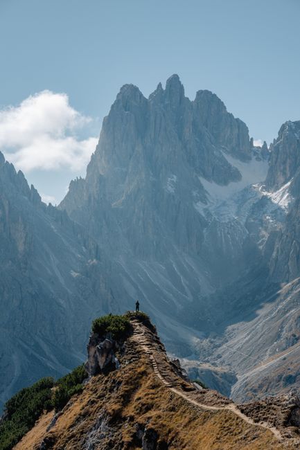 Explore the stunning mountain path in the Dolomites, Italy with breathtaking peaks and clear skies.