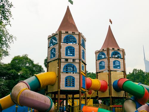 Free Two playful castle-like structures with vibrant slides in a park setting, perfect for family fun. Stock Photo