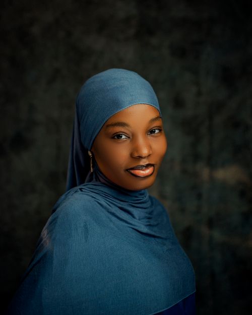 Free Elegant studio portrait of a woman wearing a blue hijab with a serene expression. Stock Photo