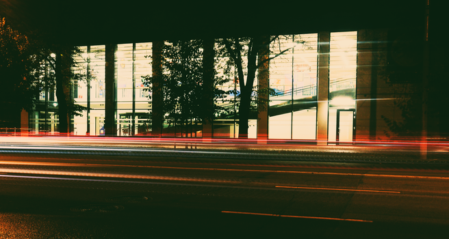 Vibrant night cityscape featuring light trails and modern architecture captured in motion.