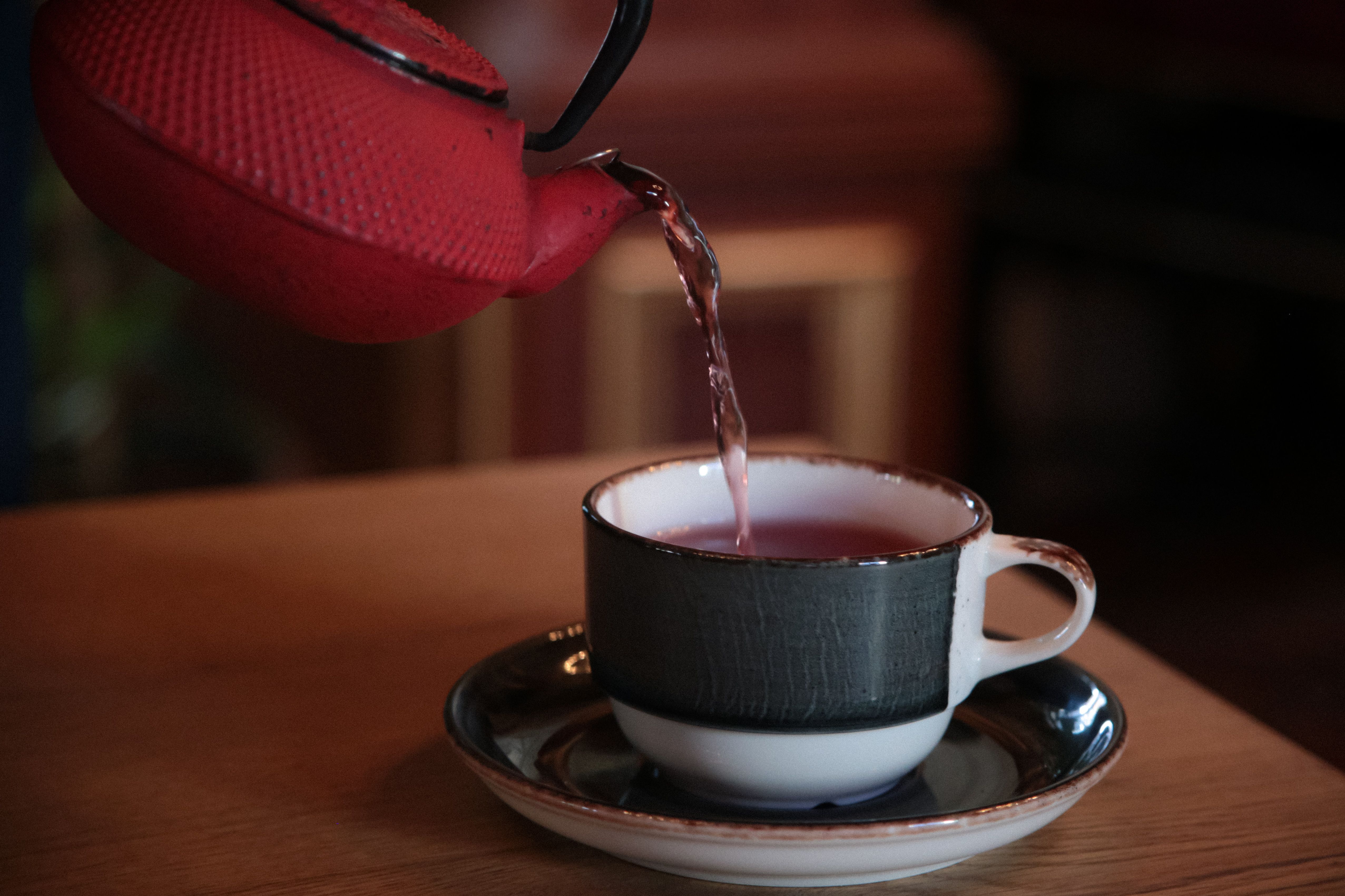 Cozy tea pouring from red kettle into cup · Free Stock Photo