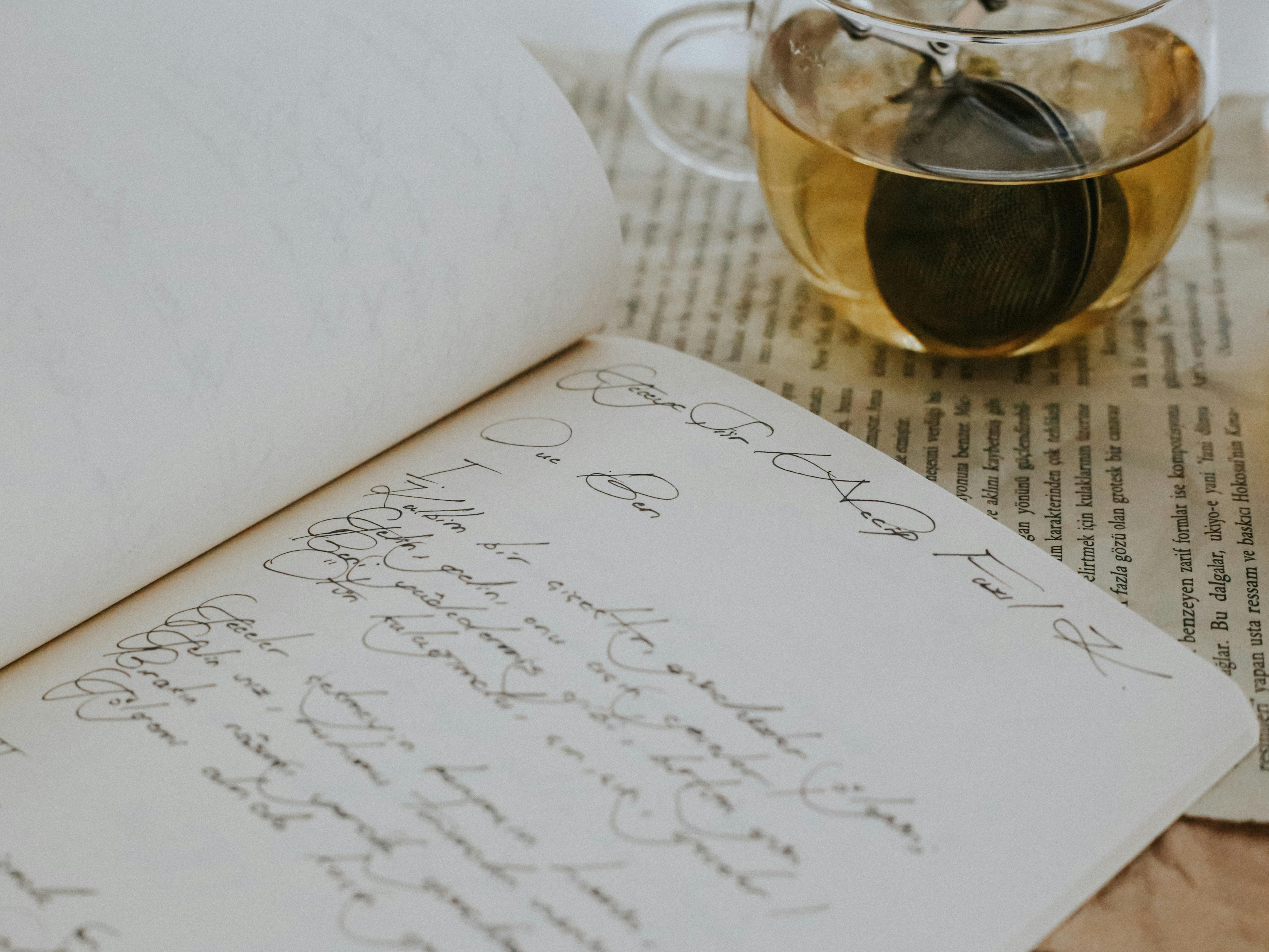Aesthetic arrangement with open diary, loose leaf tea, and vintage elements.