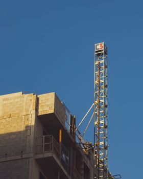Construction site with tower crane and sunset lighting. Modern urban development theme.