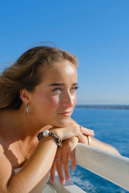 Free Young woman gazes thoughtfully at the sea from a boat in Istanbul, capturing summer's essence. Stock Photo