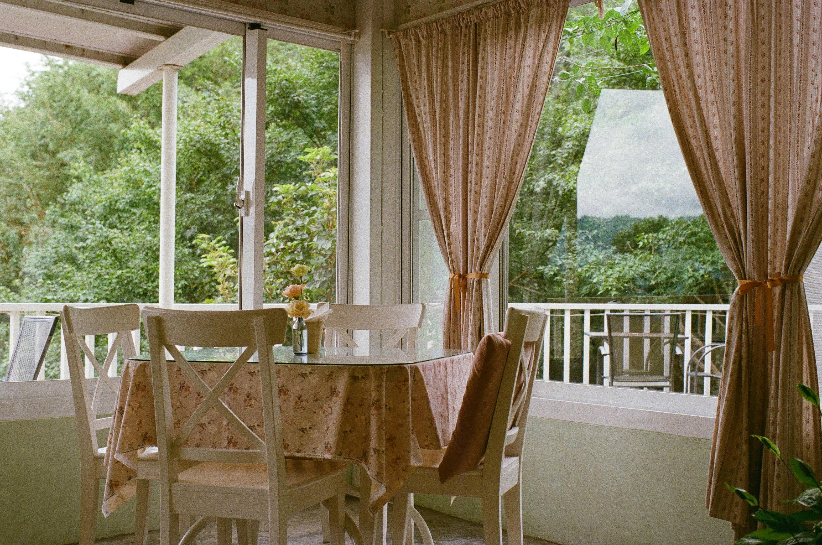 Cozy dining room with floral decor overlooking lush garden view.