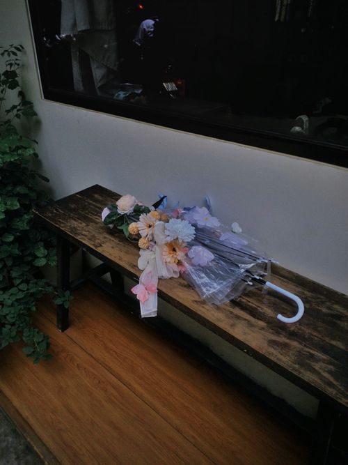 Free A bouquet of flowers resting on a transparent umbrella indoors. Stock Photo
