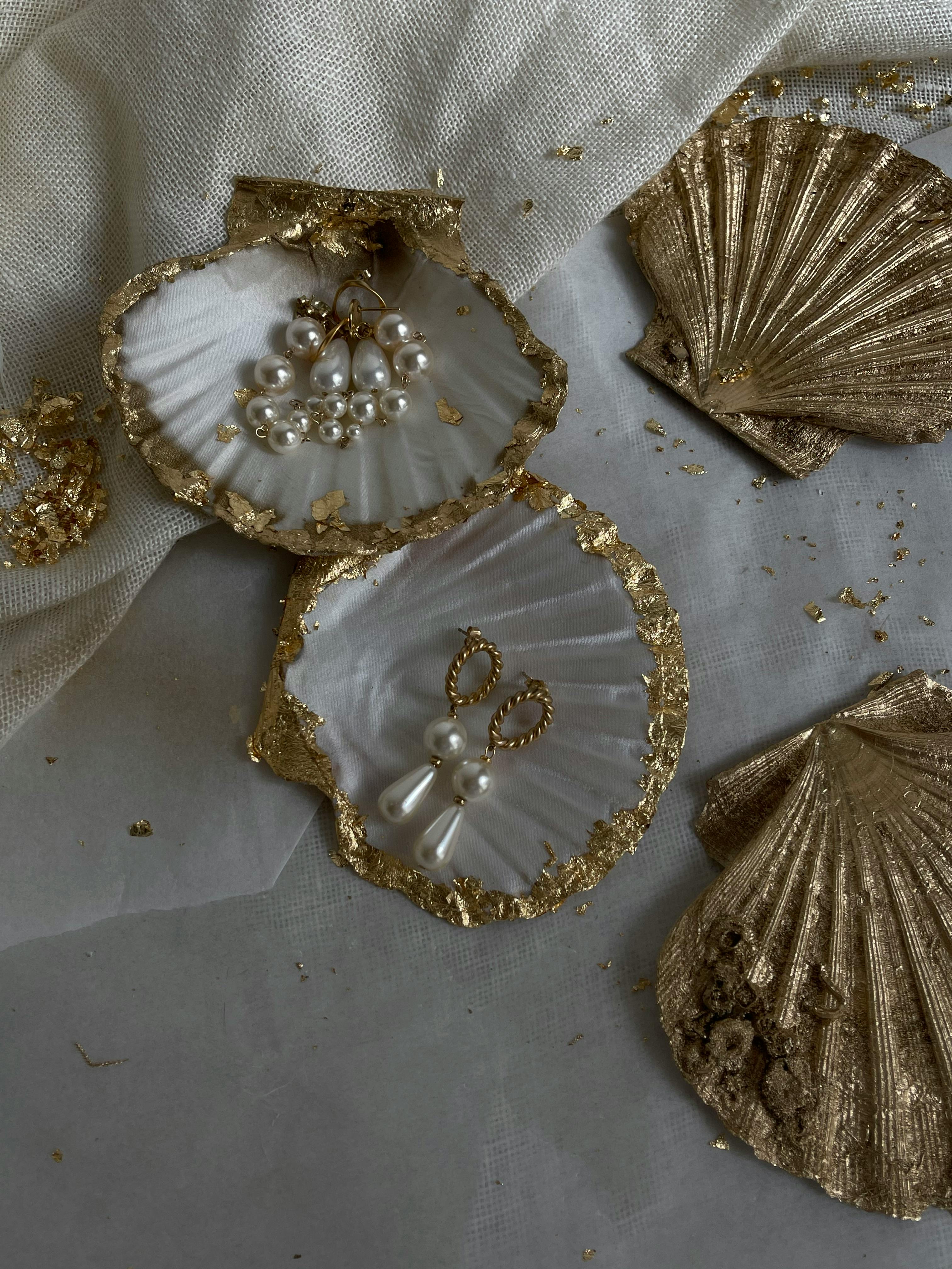 Luxurious earrings with pearls and gold on decorative seashells. Perfect for a chic, refined look.