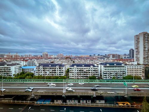 Free Aerial shot of a cityscape with residential buildings and highway under cloudy sky. Stock Photo