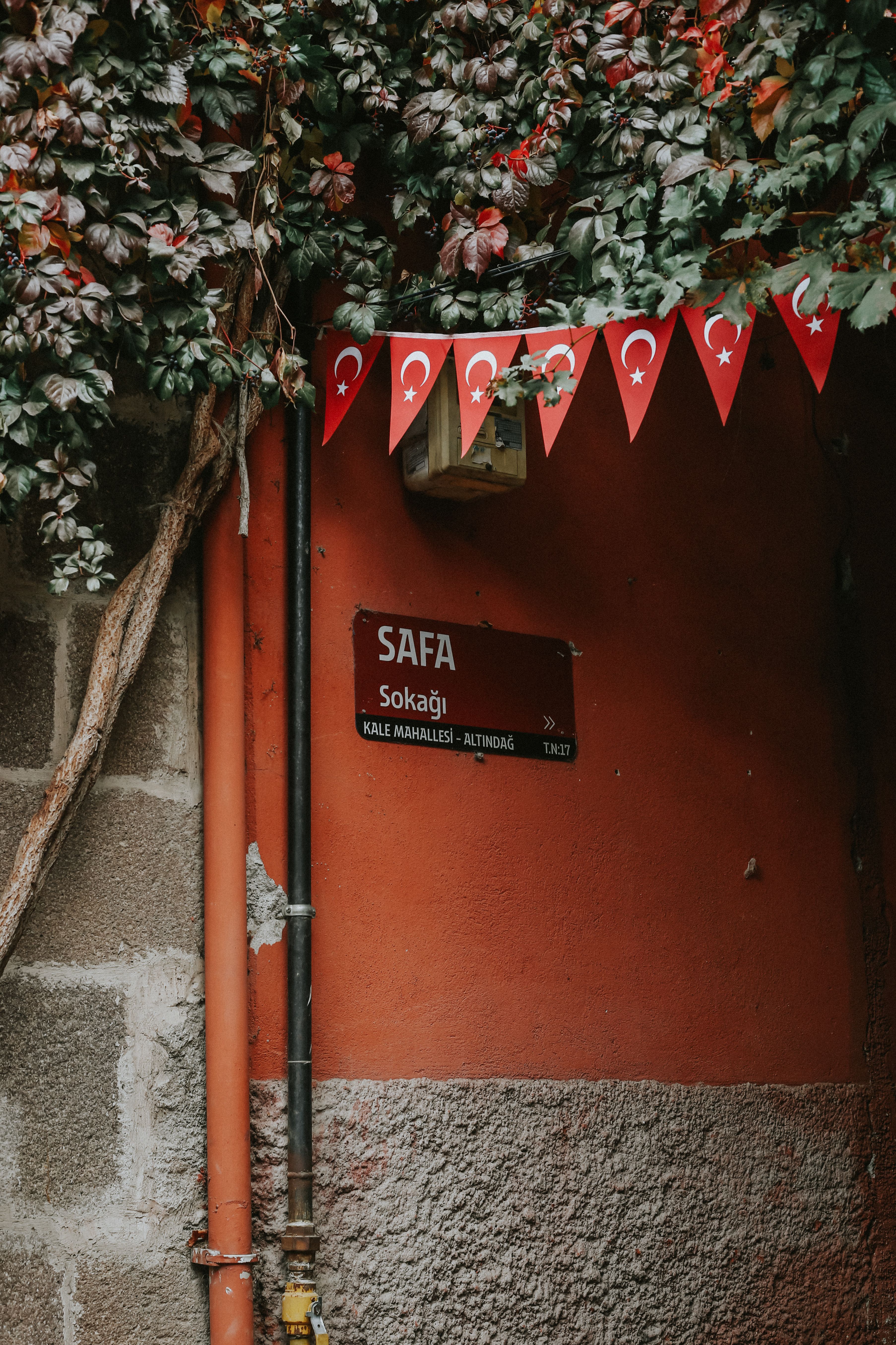 Street sign on a charming Turkish street adorned with flag bunting.