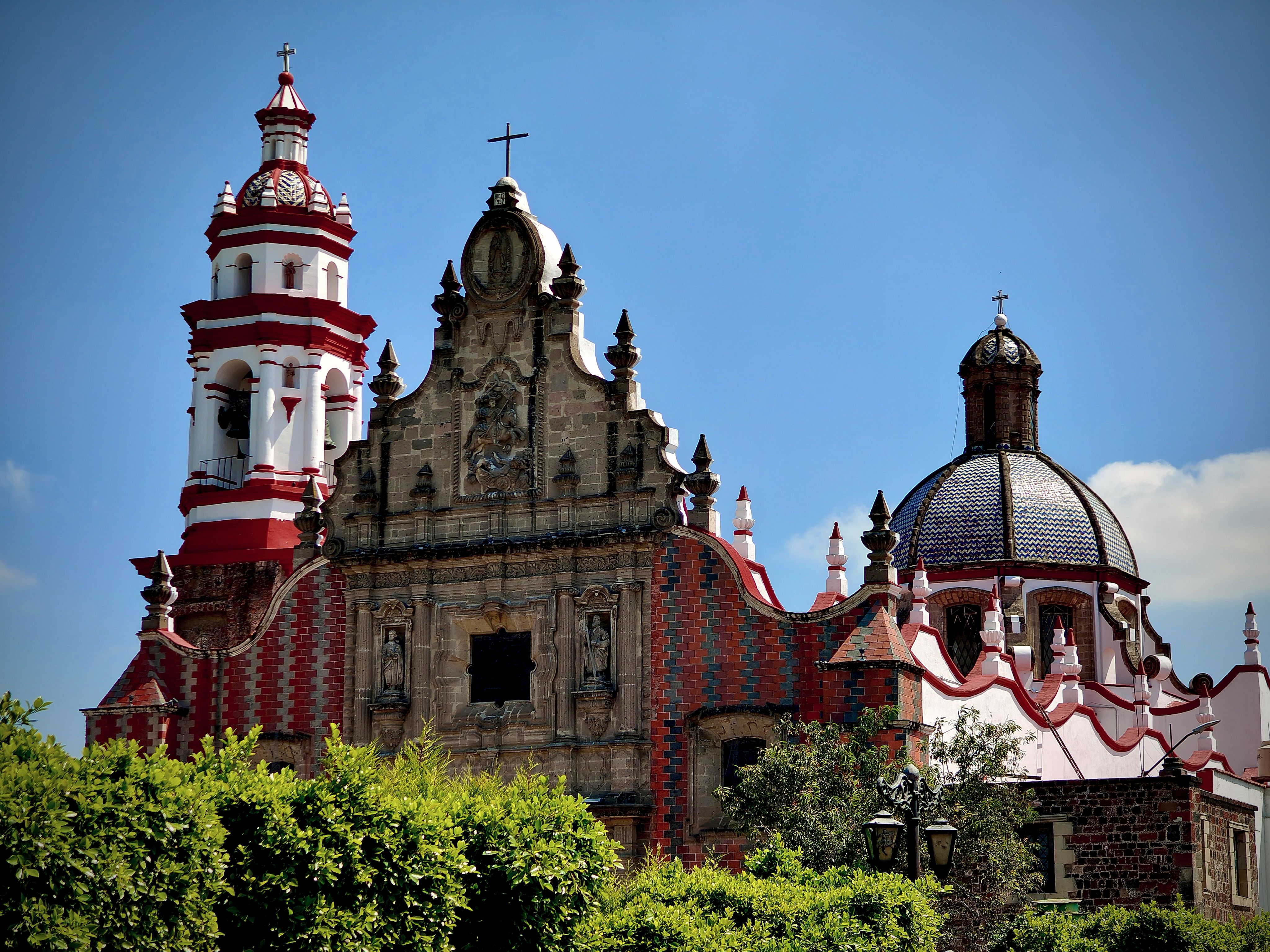 Stunning historic church in San Francisco Acatepec, Puebla, Mexico with vibrant red accents and blue sky.