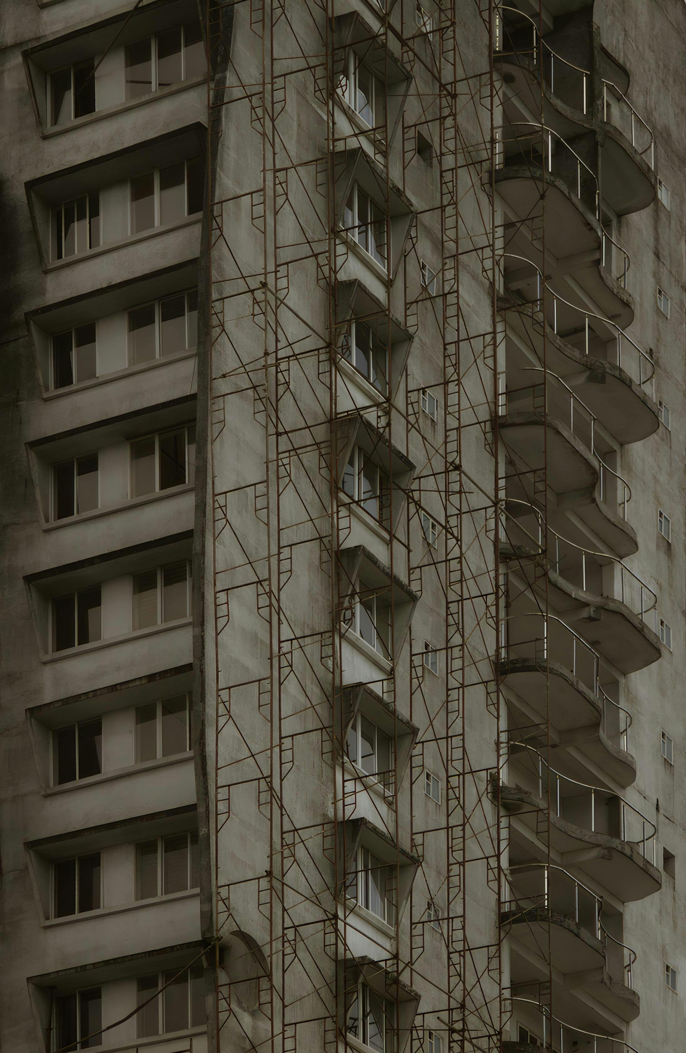 Gratis Sepia-tonet højhus under renovering med stilladser. Lagerfoto