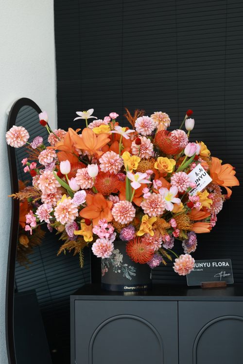 Free Lively bouquet of orange, pink, and white flowers in a stylish indoor setting. Stock Photo