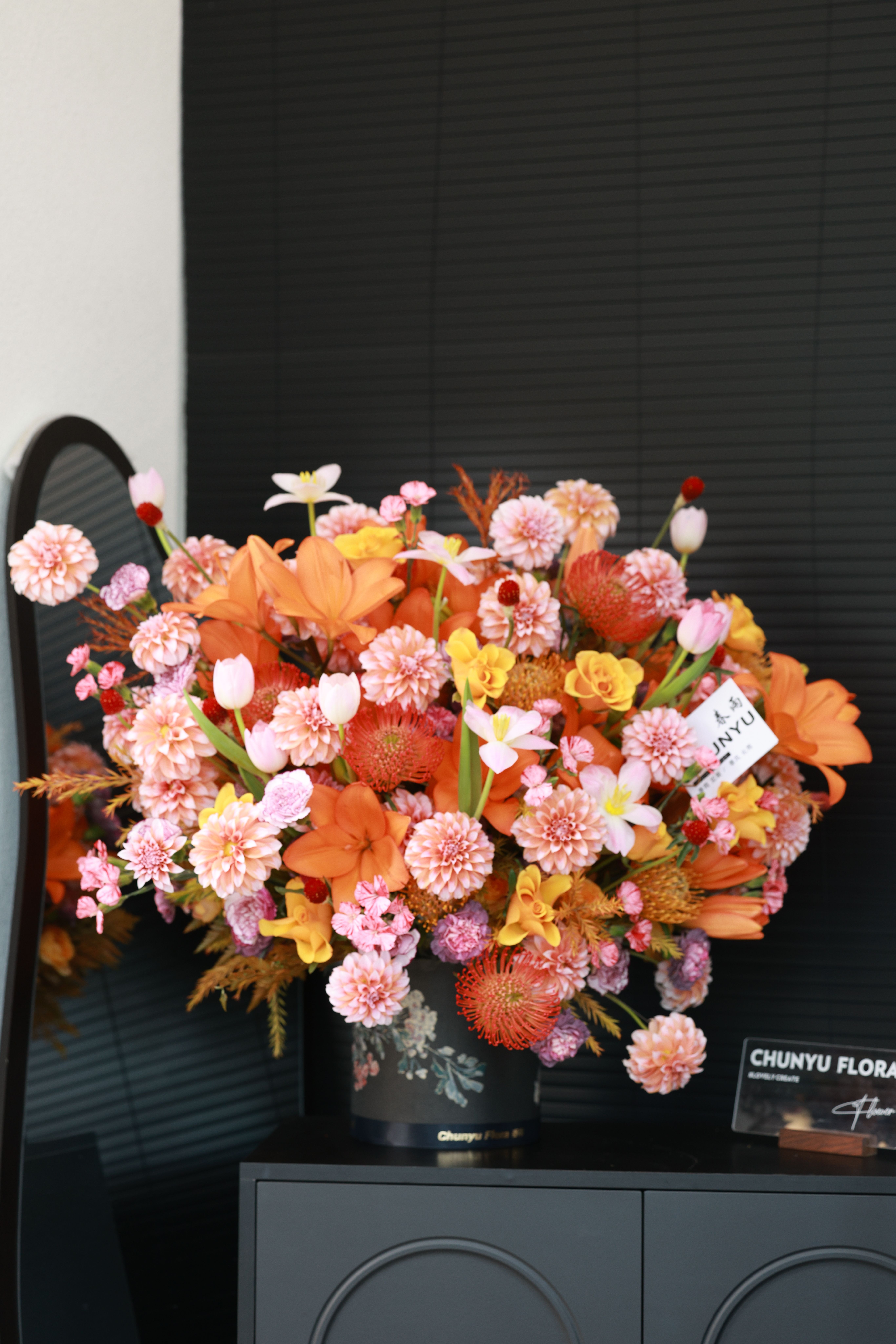 Colorful floral bouquet in a black vase against a dark backdrop. Perfect decor inspiration.