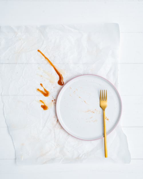 Free Gold Fork on Top of Empty White Plate Stock Photo