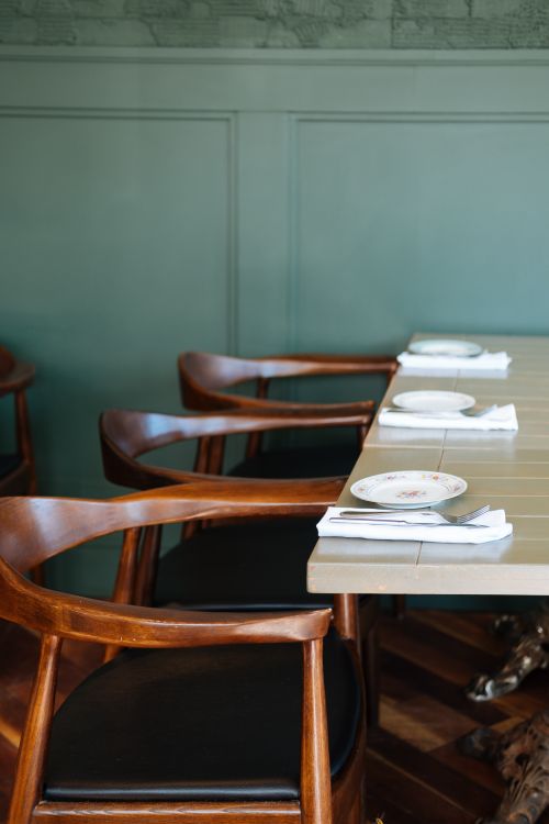 Free Stylish dining area with polished wooden chairs and set table. Stock Photo