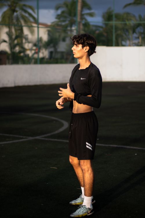 Free A young male athlete standing on an outdoor soccer field in athletic gear. Stock Photo