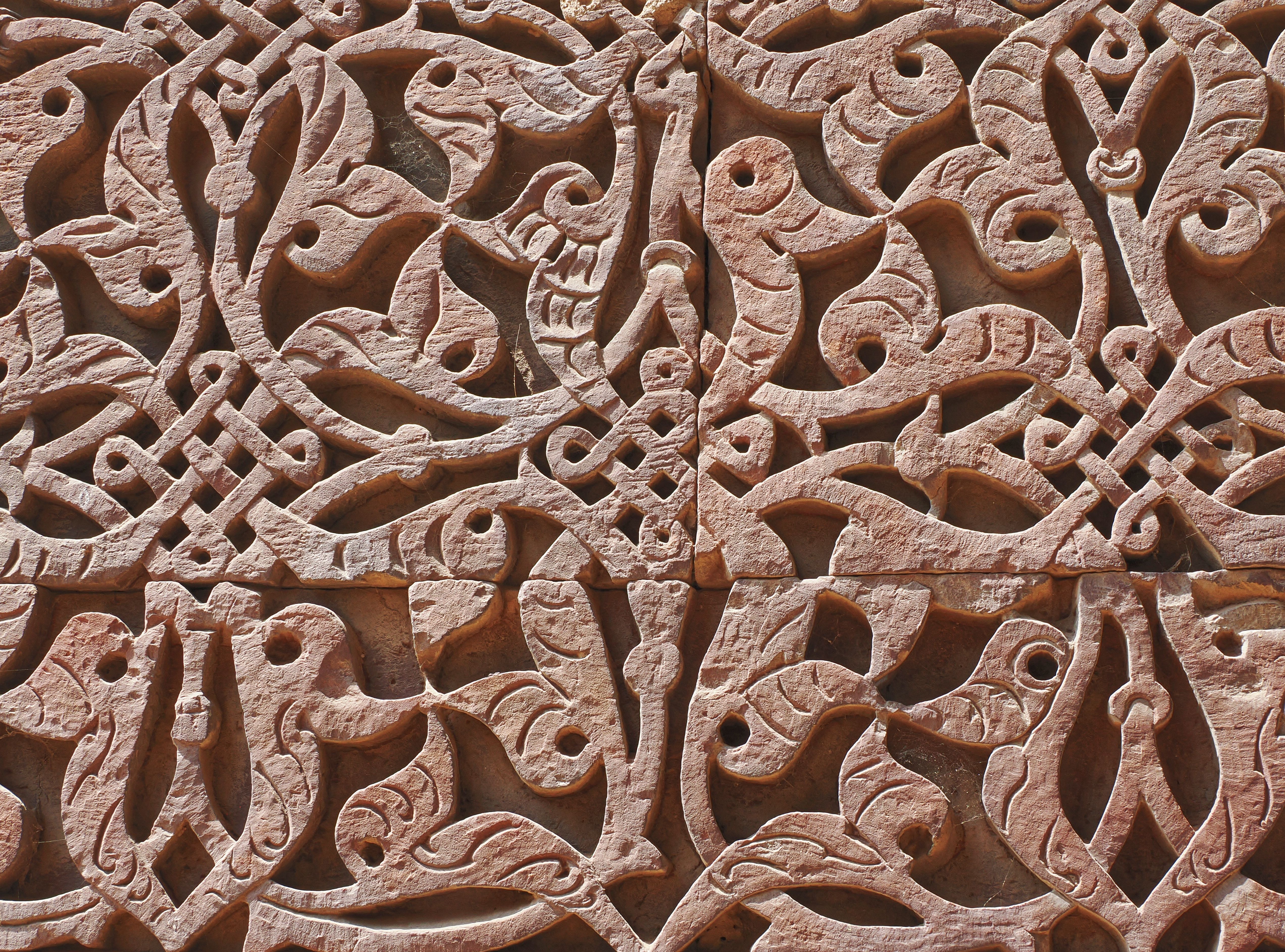 The fluted red sandstone shaft of the Qutub Minar rising above ruined arcades in Mehrauli