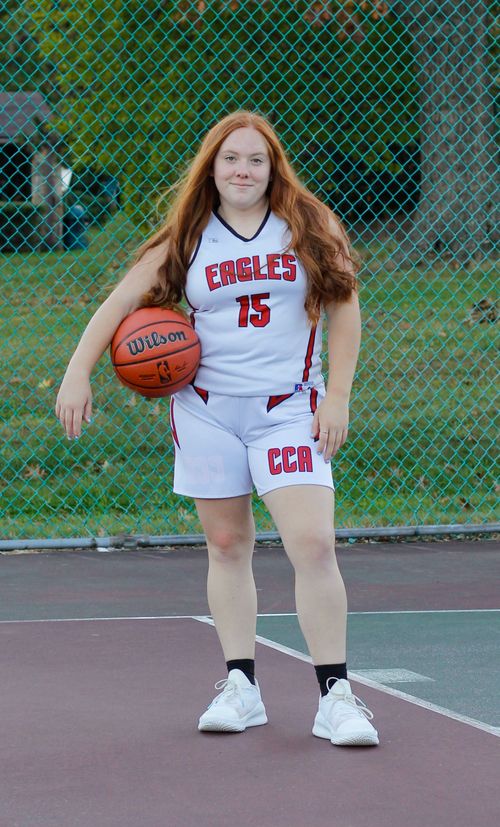 Free Teen basketball player in uniform holding a ball on an outdoor court. Stock Photo