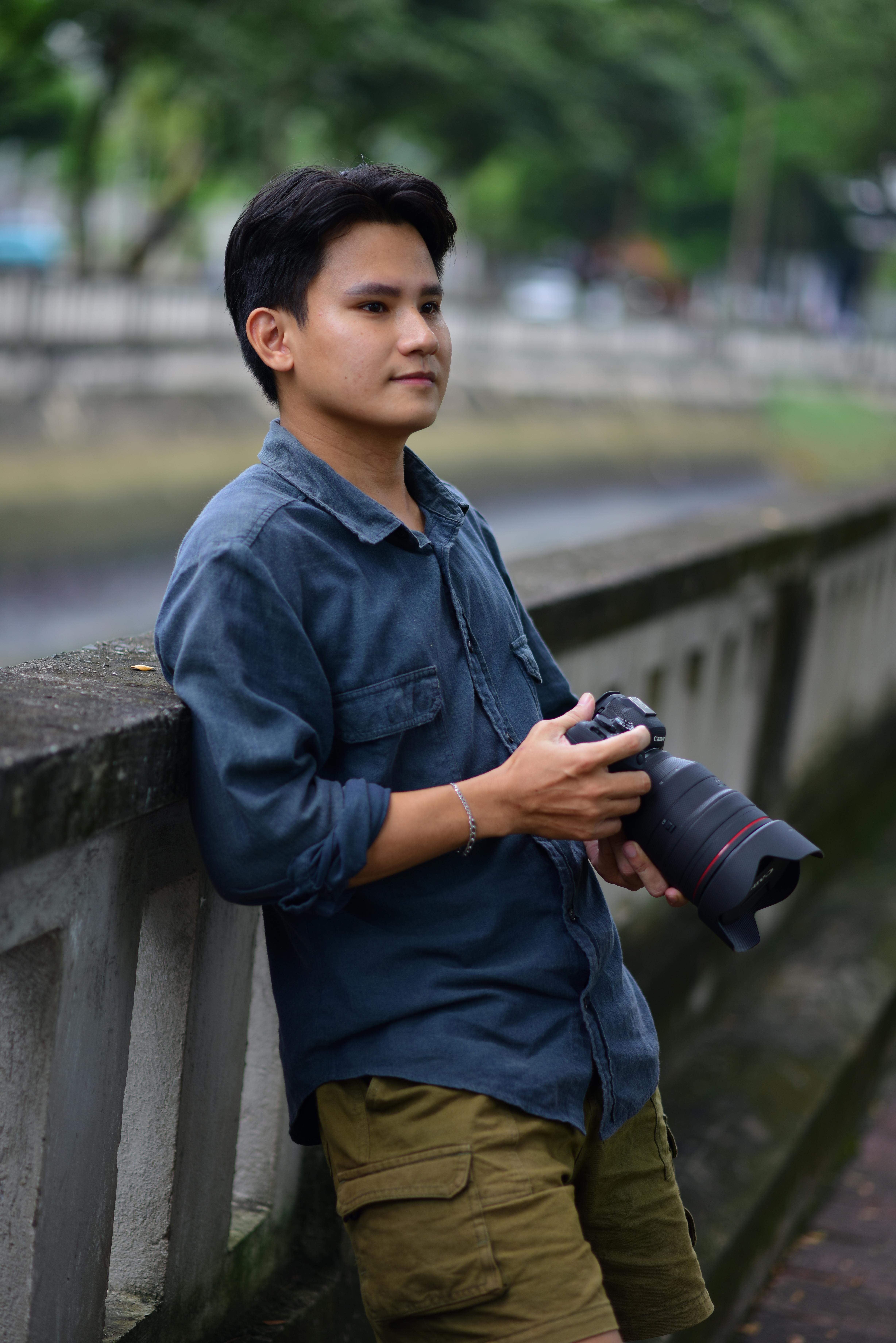 Gratuit Tânăr fotograf în ținută casual, ținând un aparat foto în aer liber. Fotografie de stoc