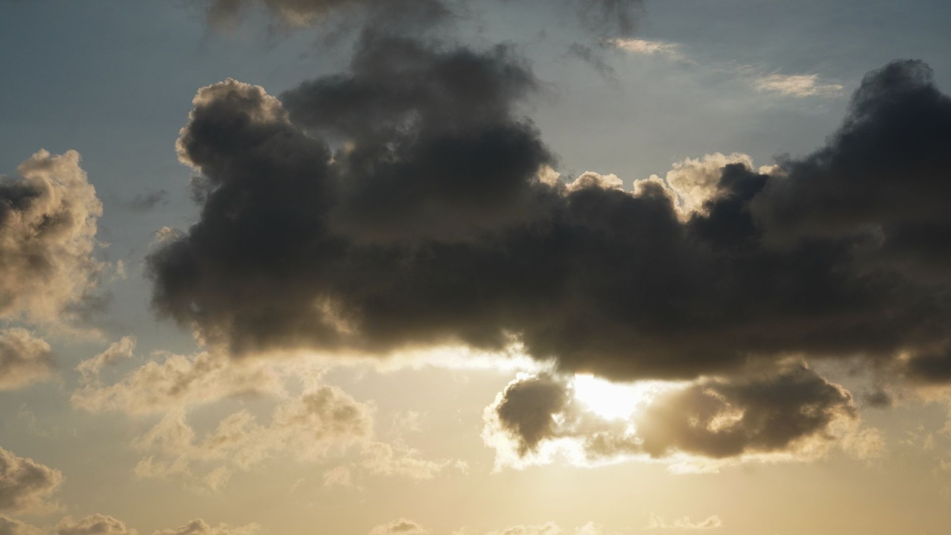 Captivating view of dark clouds engulfing the sun during a dramatic sunset.