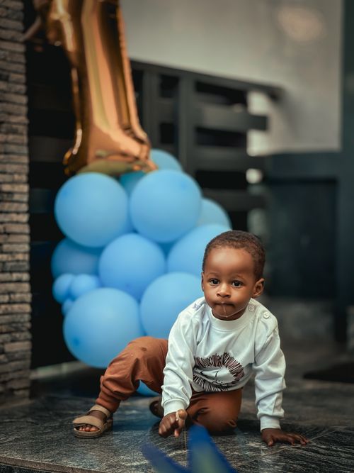 Free Cute toddler in a festive setting with balloons and a golden number one, capturing joyful moments. Stock Photo