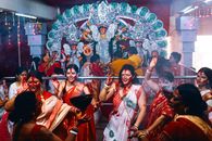Women celebrate Durga Puja with joy and traditional attire in Kolkata, India.