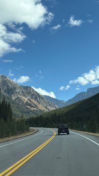 Mountain road view with a clear blue sky and distant peaks. Perfect for travel and nature enthusiasts.