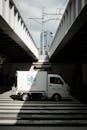 Mini Truck Crossing Under Urban Railway in Tokyo