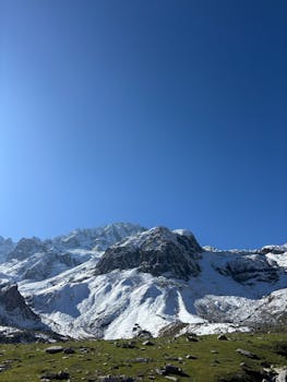 Stunning view of snow-covered alpine mountains with a vibrant blue sky.